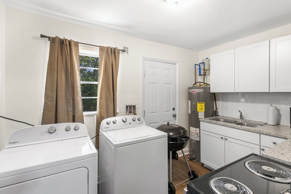 Pulling back for a full view of the laundry area placed inside the kitchen for longer-term guests.