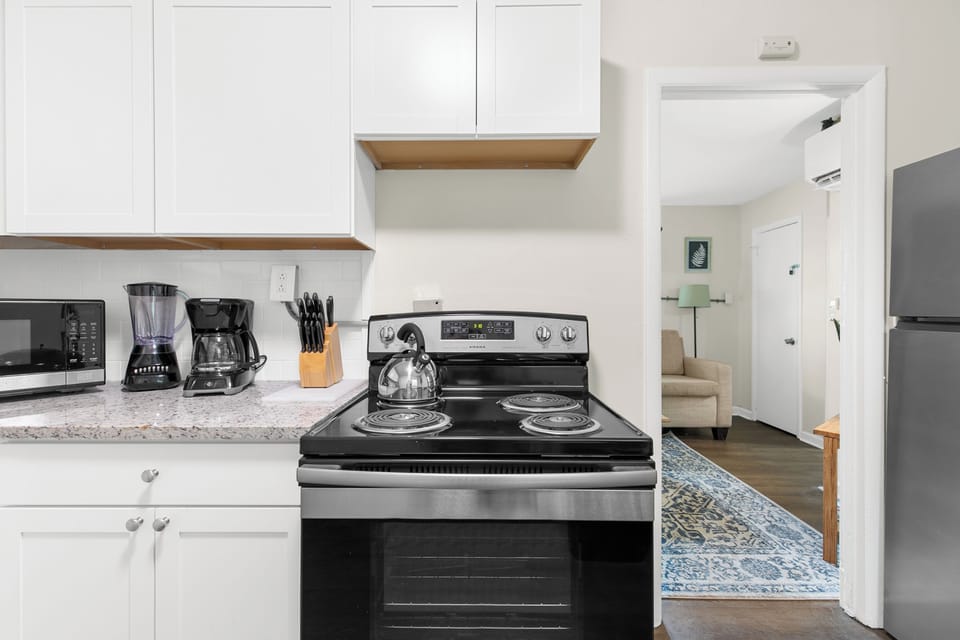 The kitchen is set up for easy use, with a full stove, oven, and coffee maker—open to the living area so everything feels connected.