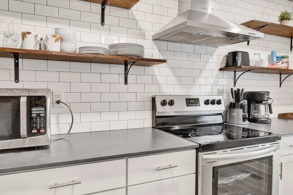 Prep meals with ease at the stove, with sleek finishes and a nearby coffee setup that keeps everything within reach and ready to go.