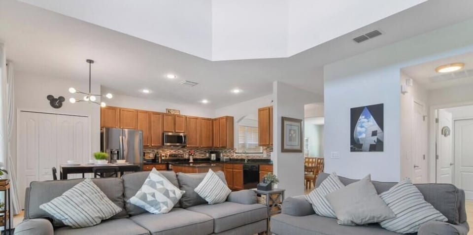 Modern open-concept living area with comfy seating and a fully equipped kitchen.