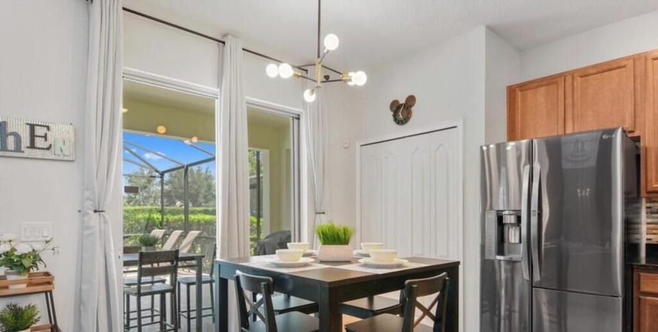 Modern kitchen with stainless steel fridge and patio access for al fresco dining.