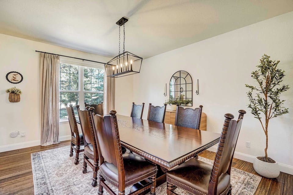 Warm pendant lighting, a generous dining table, and natural light from surrounding windows make this second dining space as fitting for a relaxed family breakfast as it is for a proper sit-down dinner.