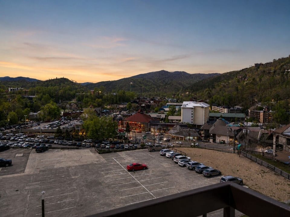 As the sun sets, the city comes alive with twinkling lights and mountain silhouettes, creating an unforgettable view from your private balcony.