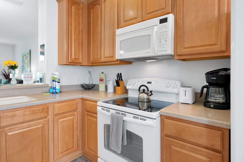 Your fully equipped kitchen features warm wood cabinets, granite countertops, and all essential appliances for preparing delicious home-cooked meals during your stay.