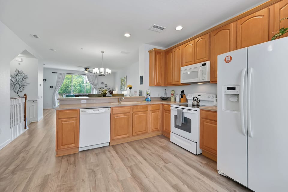 Your fully equipped kitchen awaits with warm wood cabinets, modern appliances, and an open layout perfect for preparing meals during your stay.