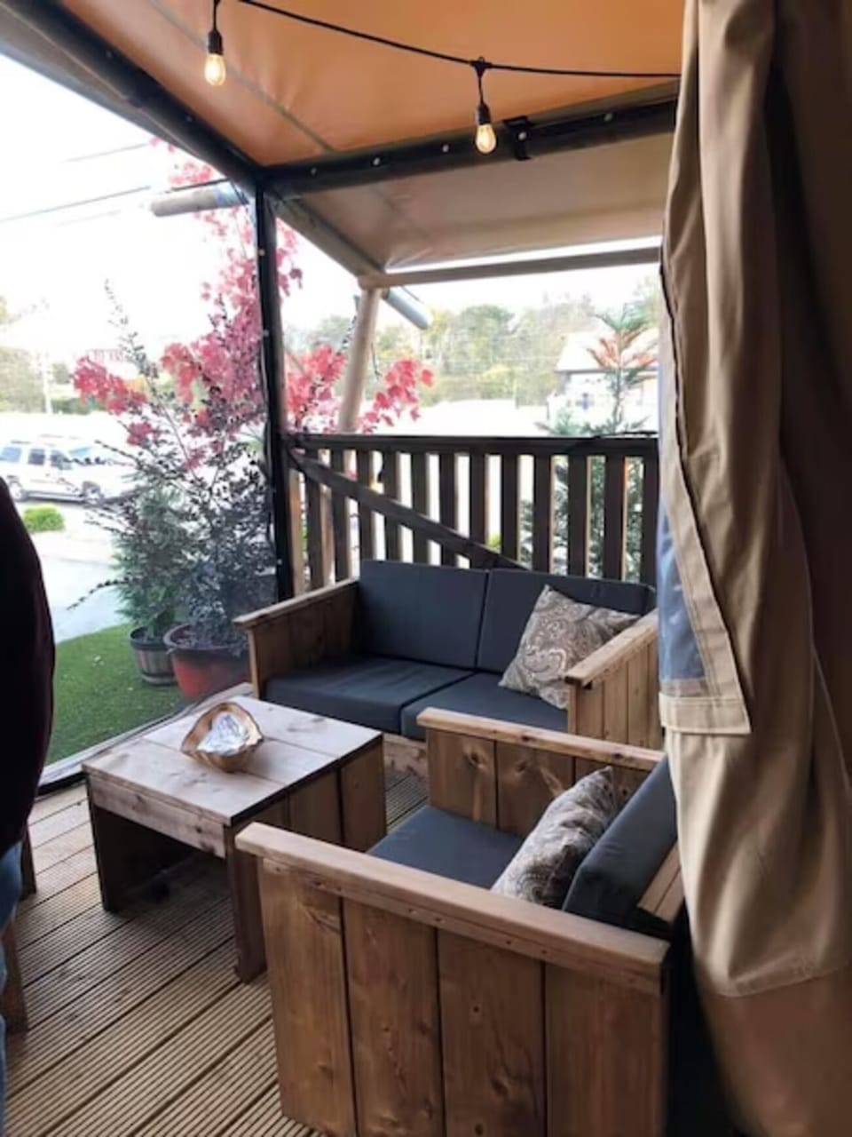 Sip morning coffee on the covered deck with soft lighting.