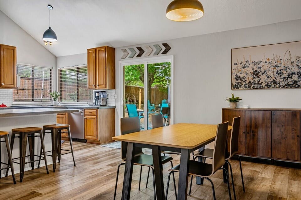 Enjoy a bright dining space with room to gather, bar seating at the kitchen counter, and direct access to the backyard patio.