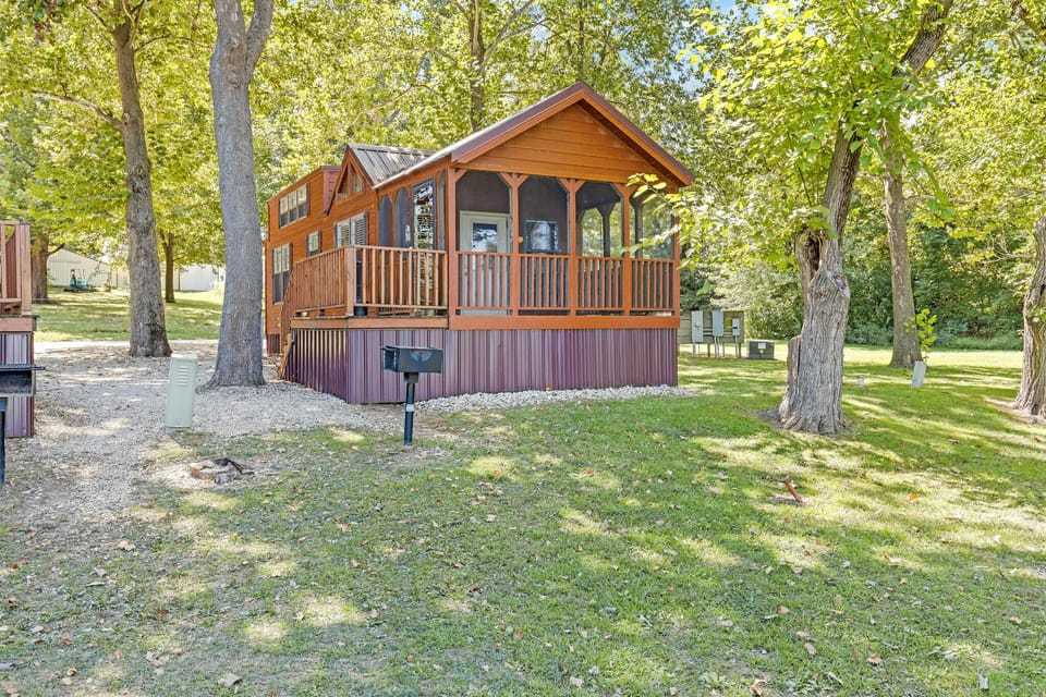 Arrive to a charming cabin framed by shady trees.