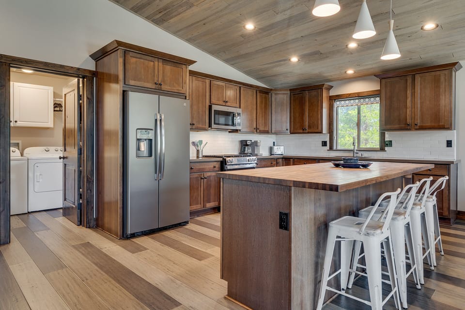 Spacious kitchen w/ stainless appliances, warm wood finishes & island seating for easy meals