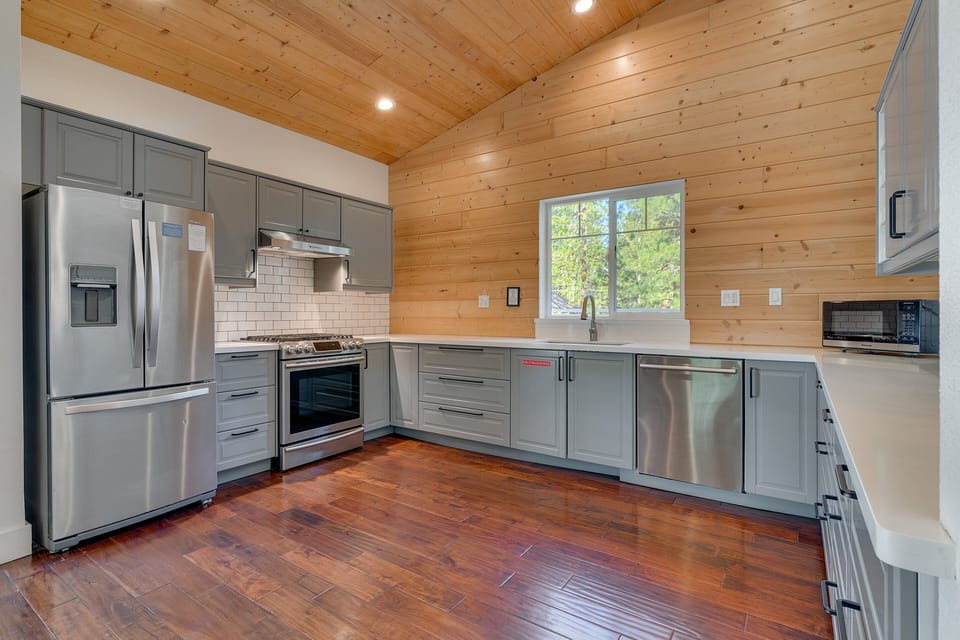 Spacious kitchen w/ stainless appliances, warm wood accents & plenty of room to cook together