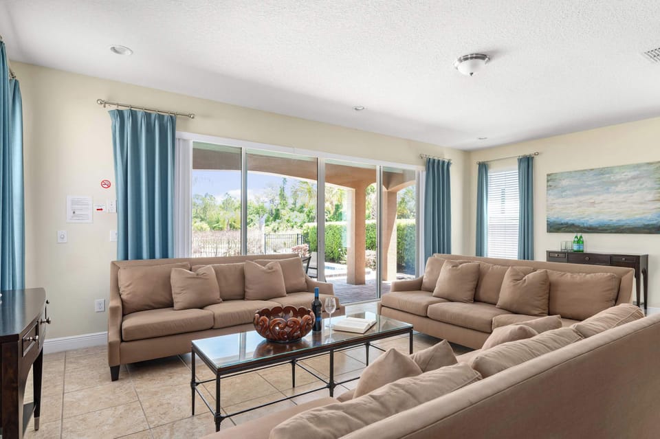 Bright living room w/ plush seating & large windows filling the space w/ natural light