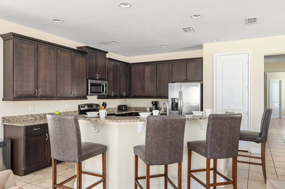 Open kitchen w/ bar seating, ample counter space & modern finishes throughout
