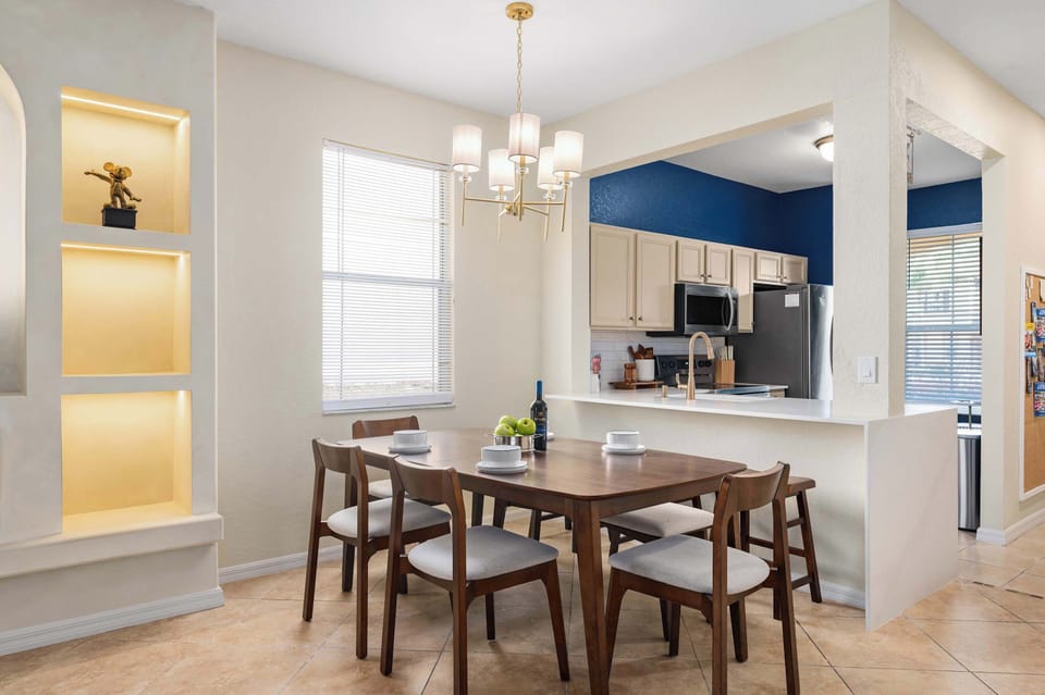 Dining space w/ statement lighting, flowing into a stylish kitchen for easy meals