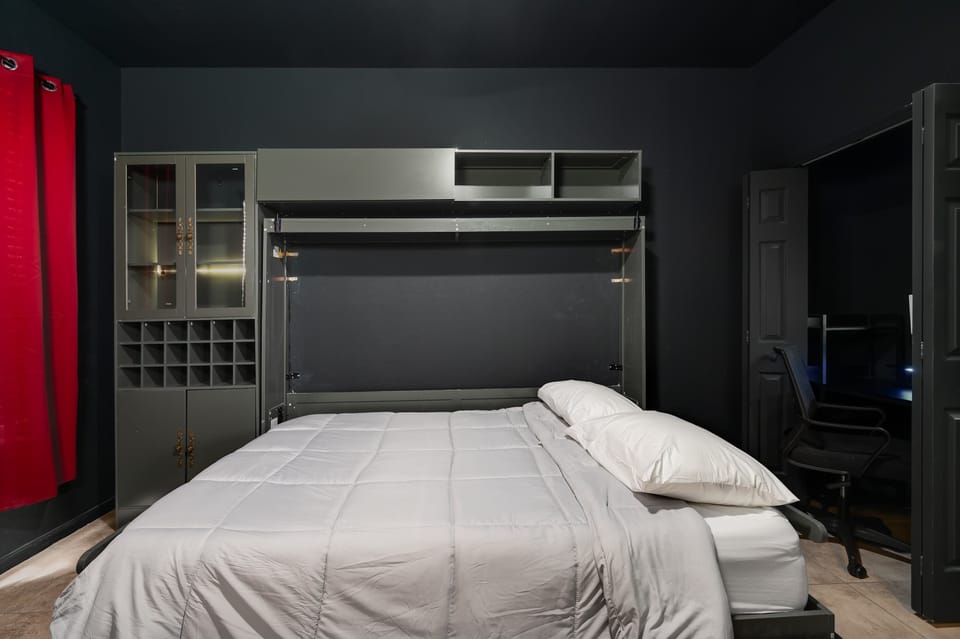 Stylish bedroom w/ fold-down bed & moody lighting for a restful stay