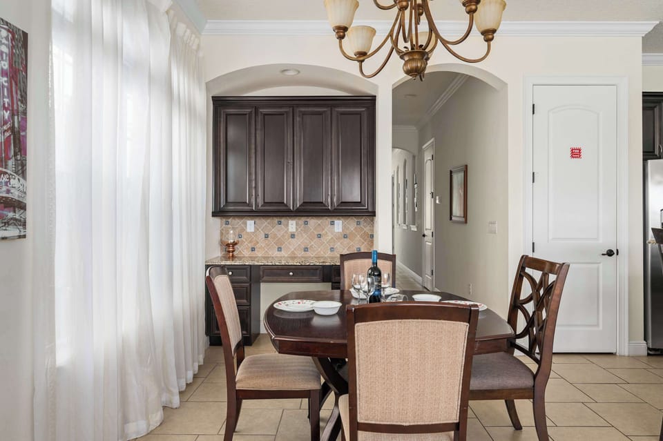 Formal dining area w/ classic furniture & soft light through sheer curtains