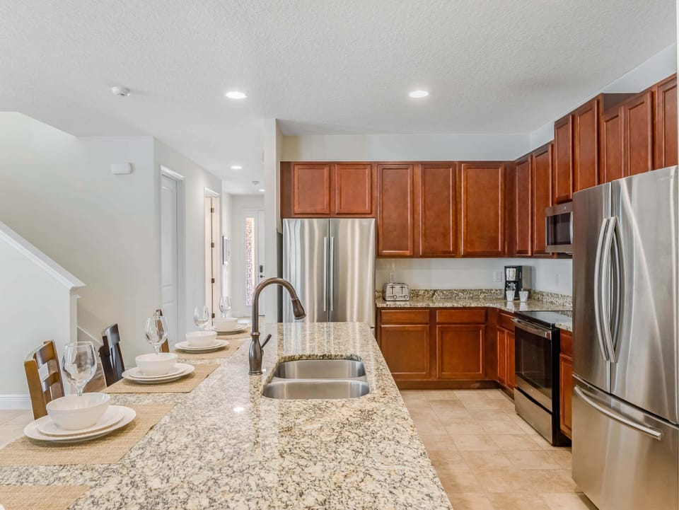 Modern kitchen w/ granite counters, stainless appliances & bar seating for casual meals