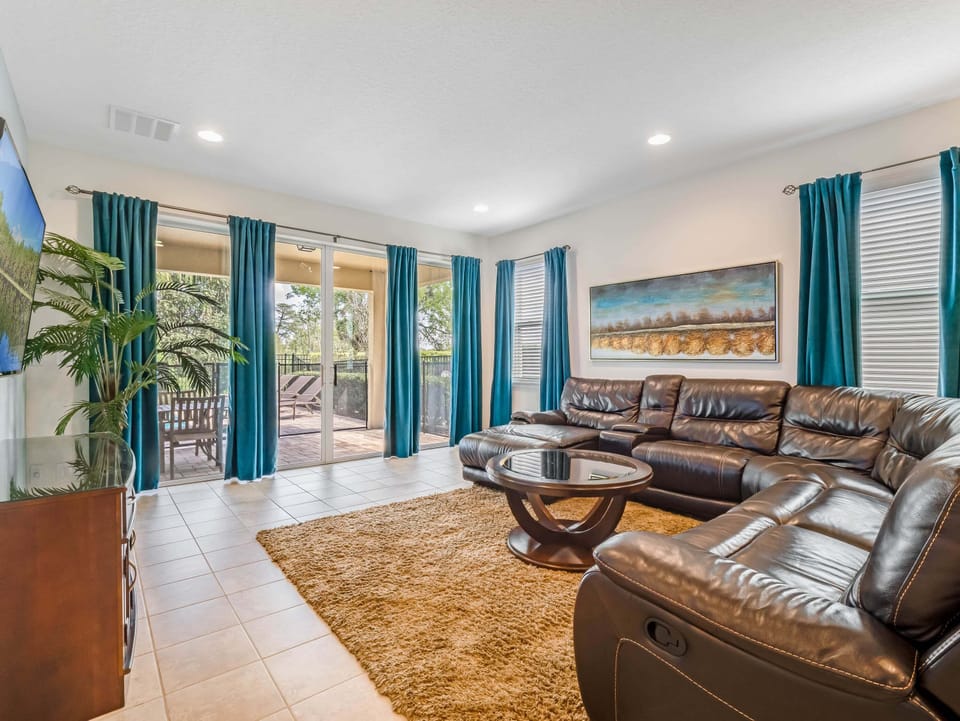 Bright living room w/ plush seating, large windows & space to gather after a day out