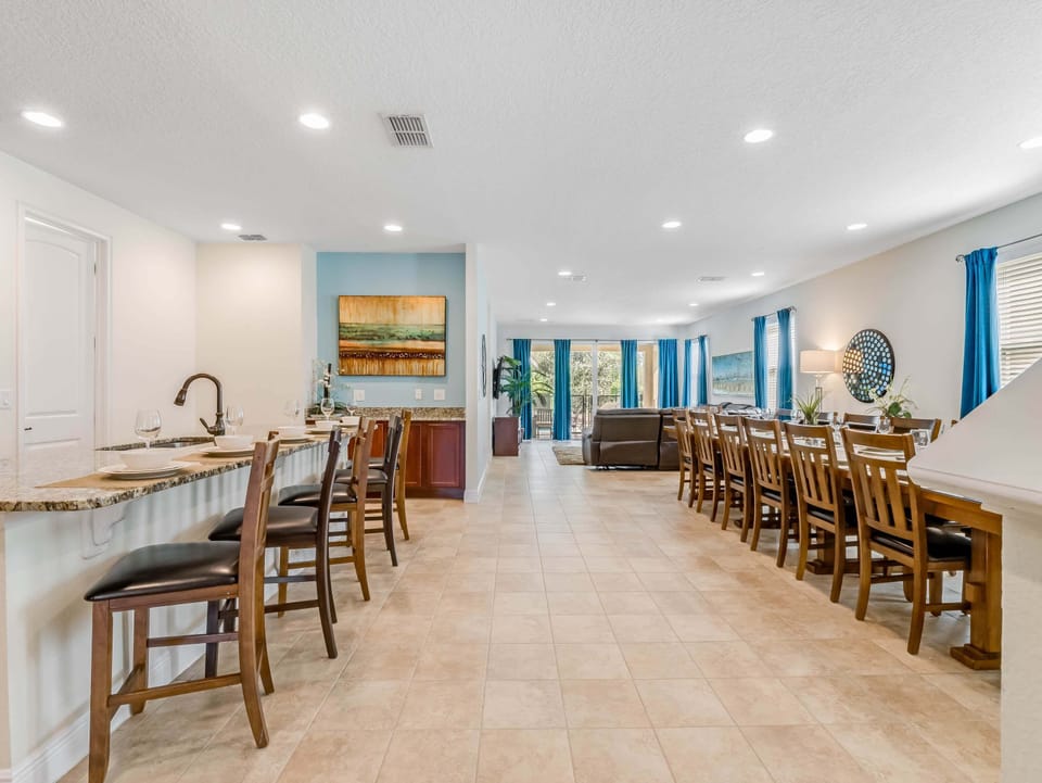 Open kitchen & dining space w/ bar seating and a long table for group meals