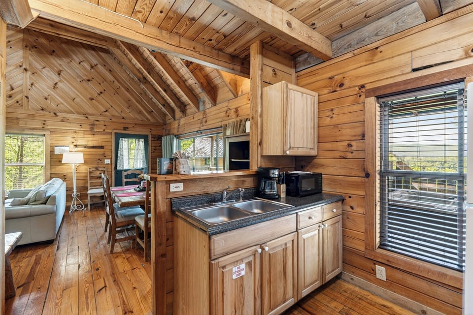 A charming, cabin-style kitchen with rustic wood finishes and a breakfast bar—perfect for easy mornings and casual meals.