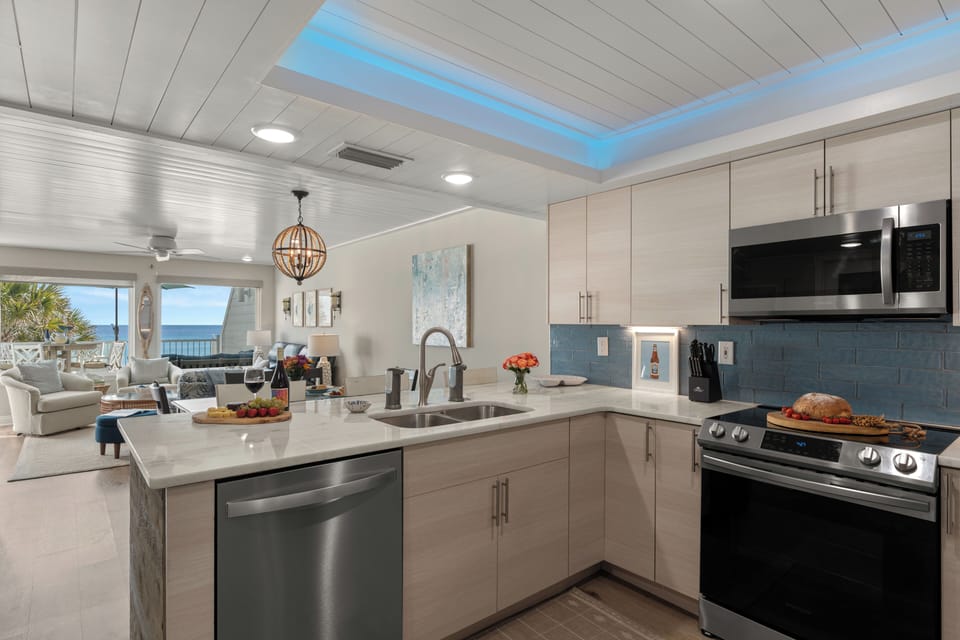 Fully equipped kitchen featuring a deep stainless steel sink, dishwasher, and more.
