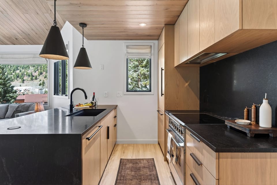 Bright and airy kitchen workspace with ample storage and mountain views.