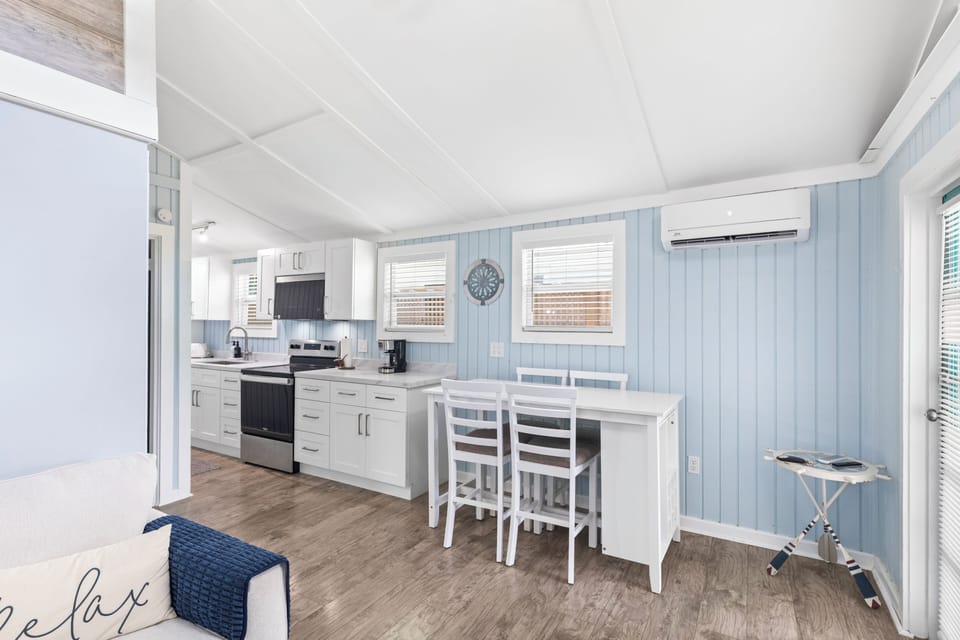 Fully equipped kitchen with white appliances and a subway tile backsplash.