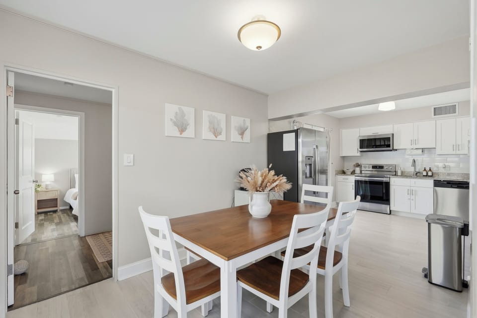 This bright and inviting dining room with seating for 6 is surrounded by windows that fill the space with natural light and offer serene backyard views, perfect for family meals and leisurely breakfasts.