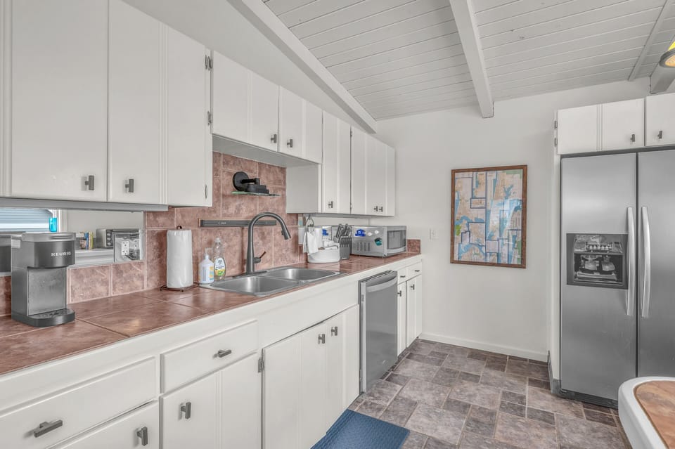 Your fully equipped kitchen awaits with sleek appliances, ample counter space, and charming exposed beam ceiling for comfortable meal preparation.