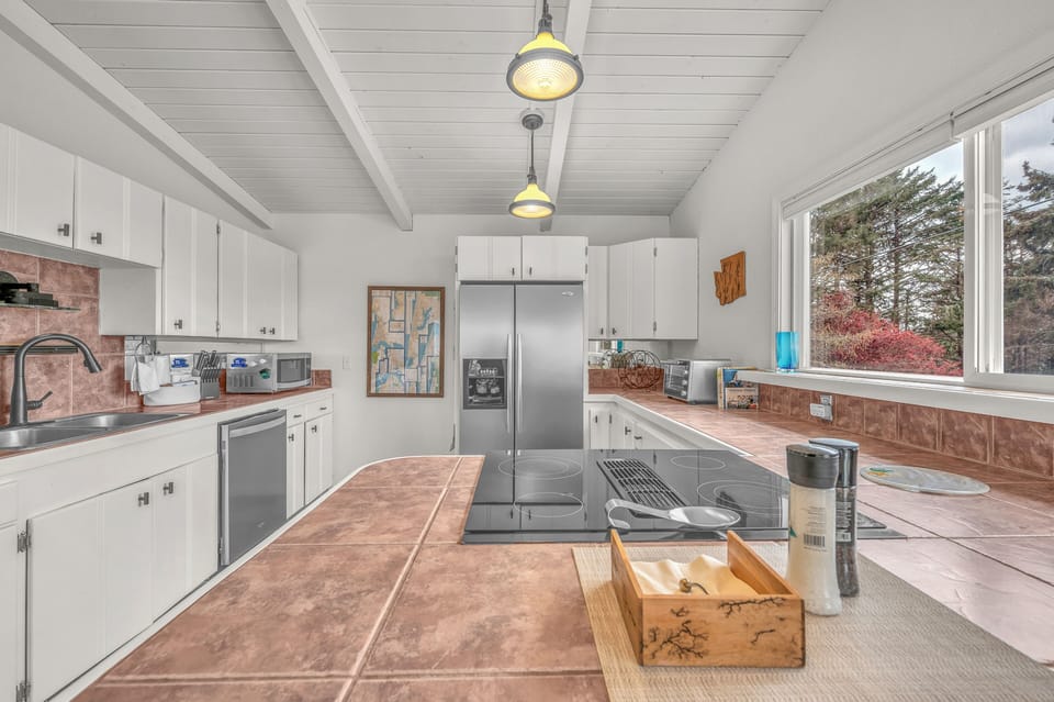 Cook your favorite meals in this spacious, fully-equipped kitchen with modern appliances and charming exposed ceiling beams.