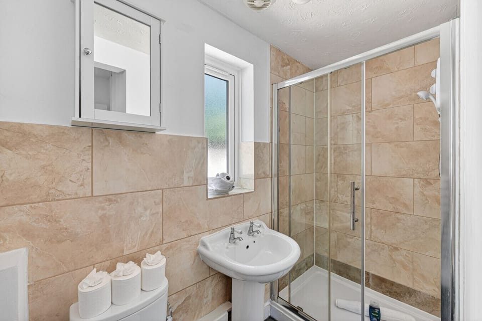 The bathroom features a walk-in shower with complimentary toiletries provided.