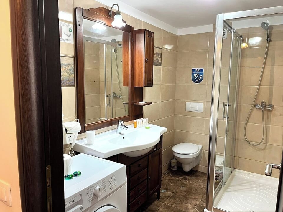 Well-appointed and modern bathroom with a vanity, mirror, and ample counter space, providing a comfortable and functional space for guests to refresh and prepare for the day.

