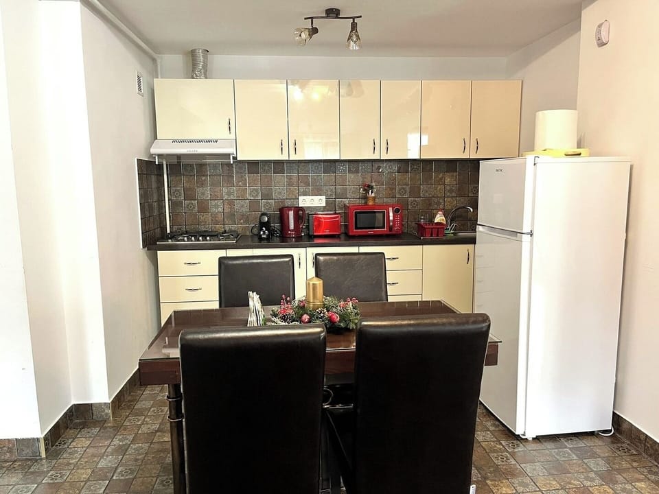 Open-concept layout of the apartment, with the kitchen and dining area seamlessly integrated;  sophisticated and inviting atmosphere. The space is well-lit, with recessed lighting and pendant fixtures adding to the overall ambiance.