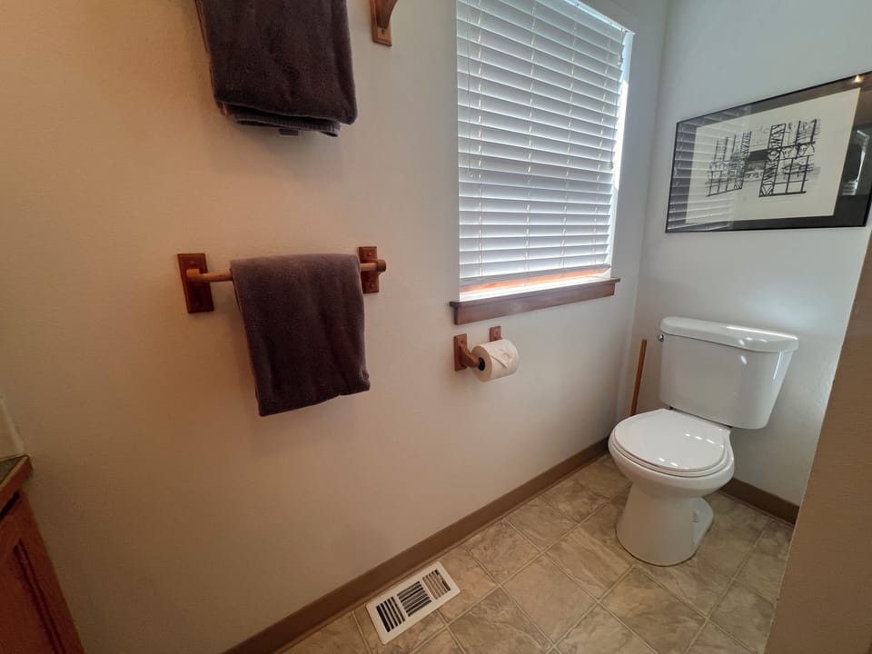 Your bathroom features a modern toilet with plush towels and stylish tile ceiling details creating a comfortable, well-appointed space.
