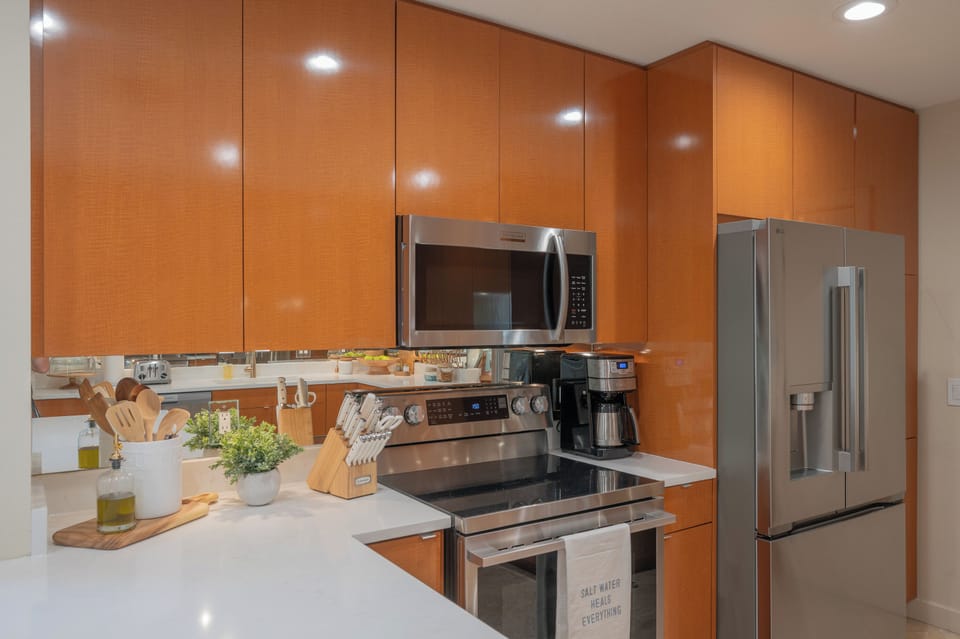 Your sleek modern kitchen features stainless steel appliances and warm wood cabinetry, creating the perfect space for preparing memorable meals.