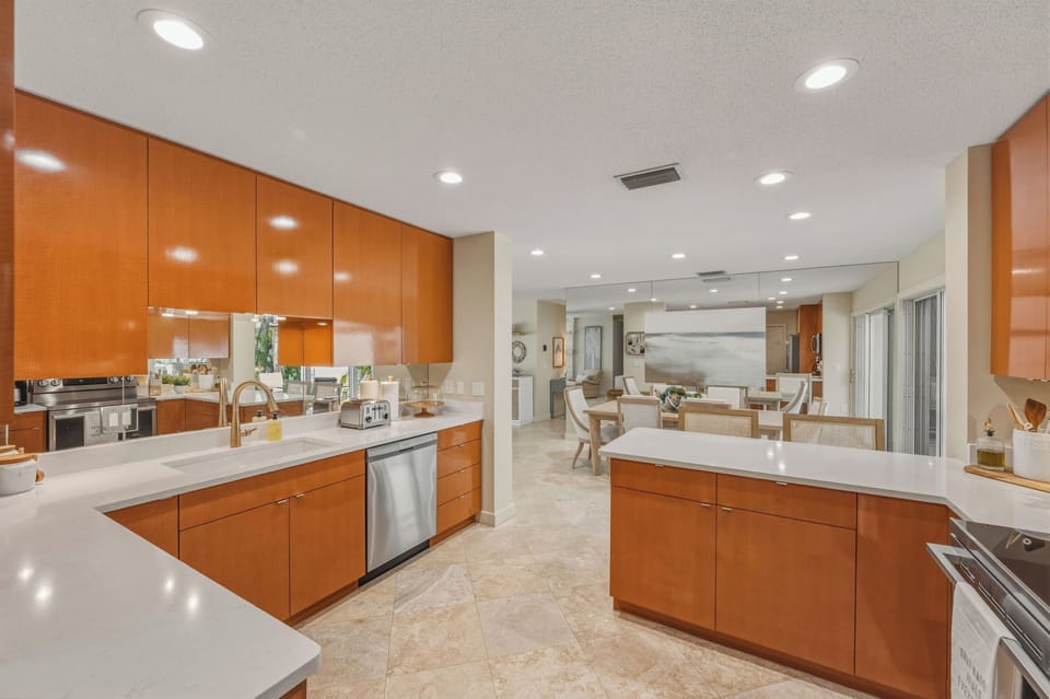 You'll love creating culinary masterpieces in this modern kitchen featuring sleek  cabinets, pristine white quartz countertops, and premium stainless steel appliances.