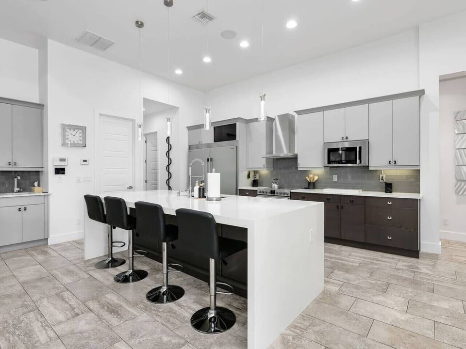 The open-concept kitchen features a large island with bar seating, modern appliances, and plenty of space for guests to cook and gather.