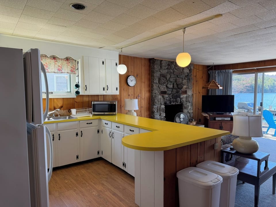 Your spacious open kitchen flows into the cozy living area, with stunning lake views beckoning through every window.