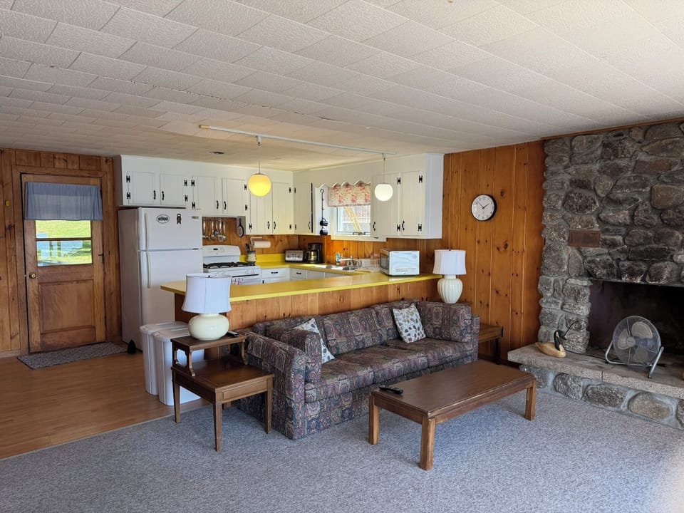Cozy open-concept living with stone fireplace and fully equipped kitchen - your perfect home base for mountain getaways.