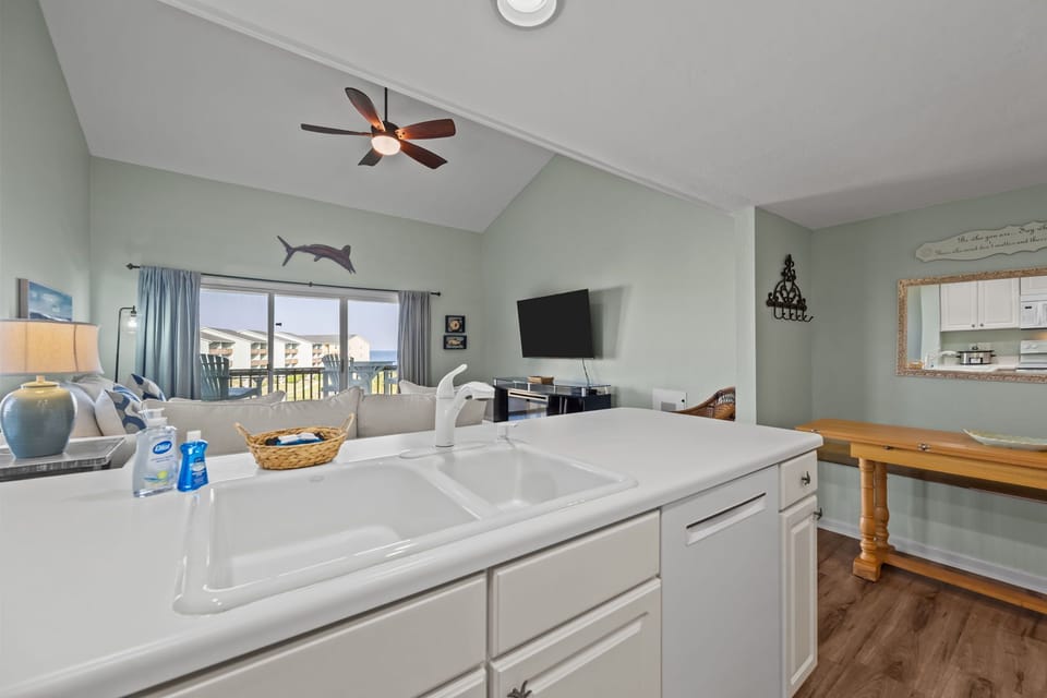Kitchen island with sink overlooking the living room and balcony views
