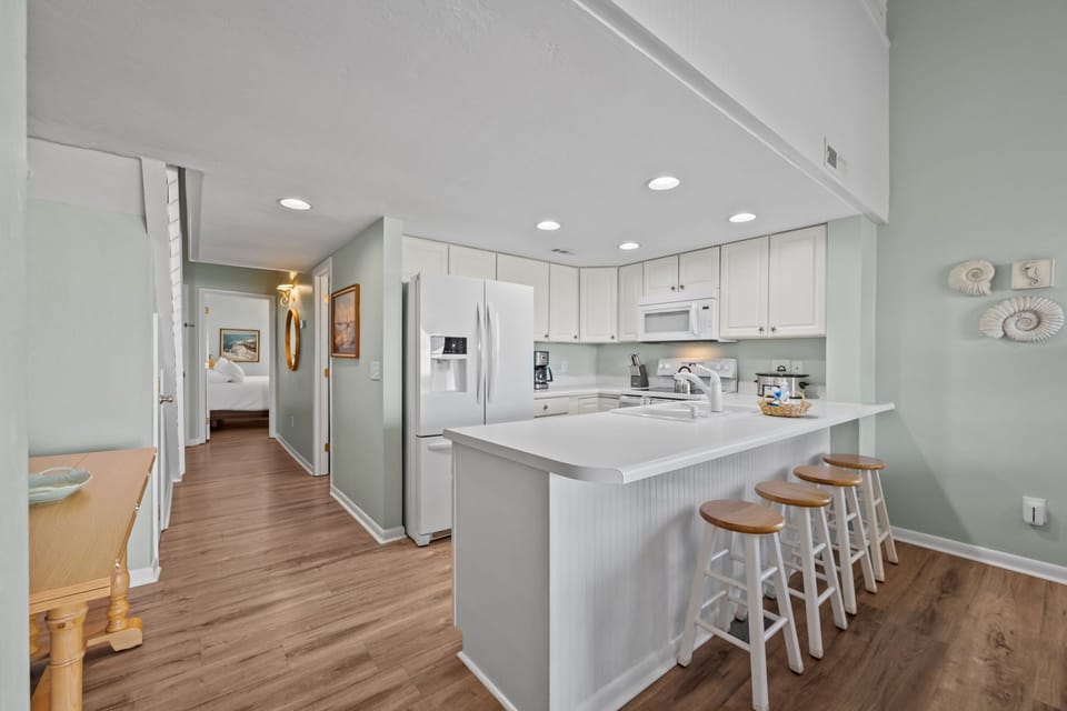 Open kitchen with bar seating for four and easy flow into the living area