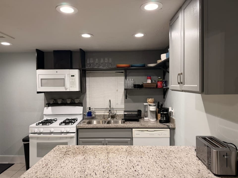 Fully equipped kitchen with gas stove, microwave woven, dishwasher, coffee station and dinner ware