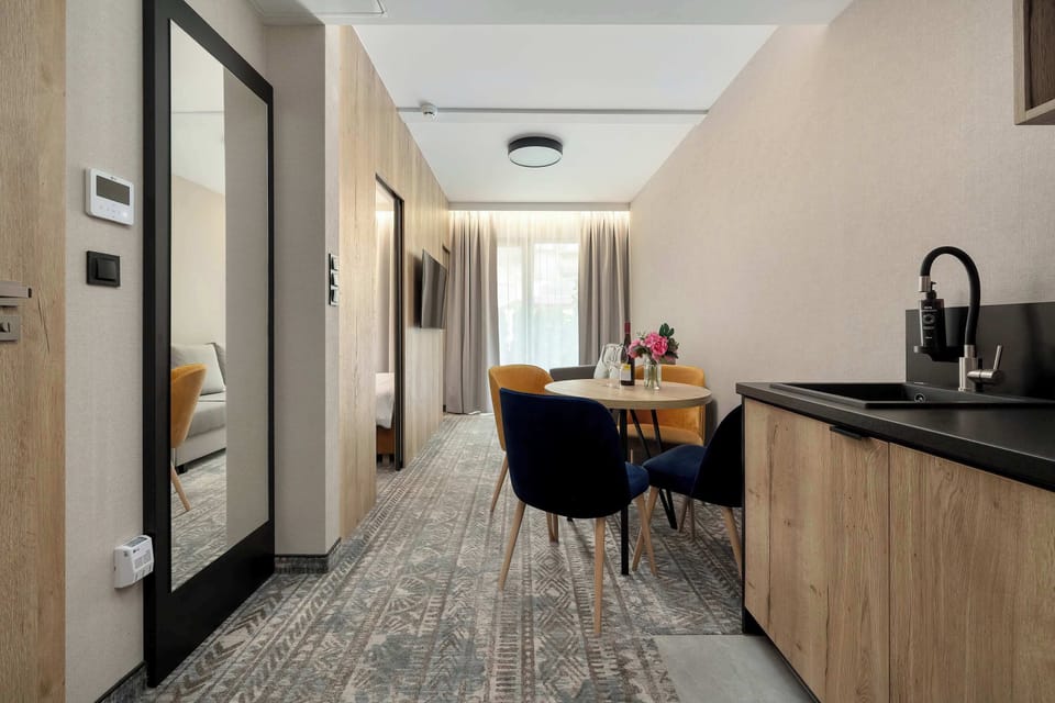 A narrow hallway leading into a kitchenette and seating area. The layout is efficient and well-organized for a compact space.