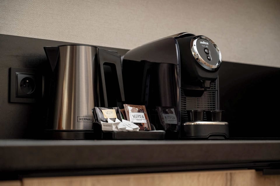 A close-up of a coffee machine on a kitchen counter. It suggests convenience for making drinks in the room.