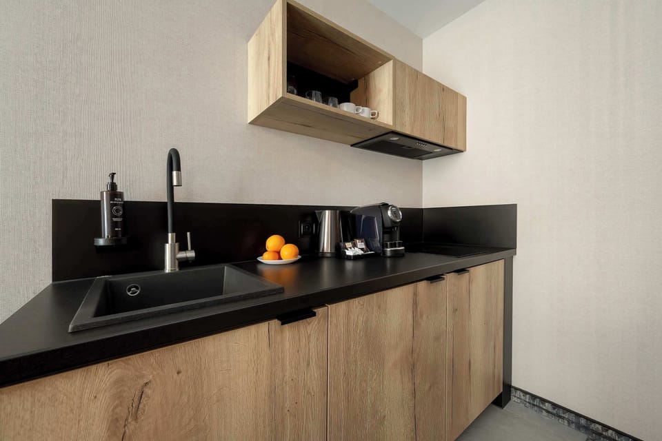 Another view of the kitchenette with clean surfaces and built-in appliances. The design emphasizes practicality and modern style.