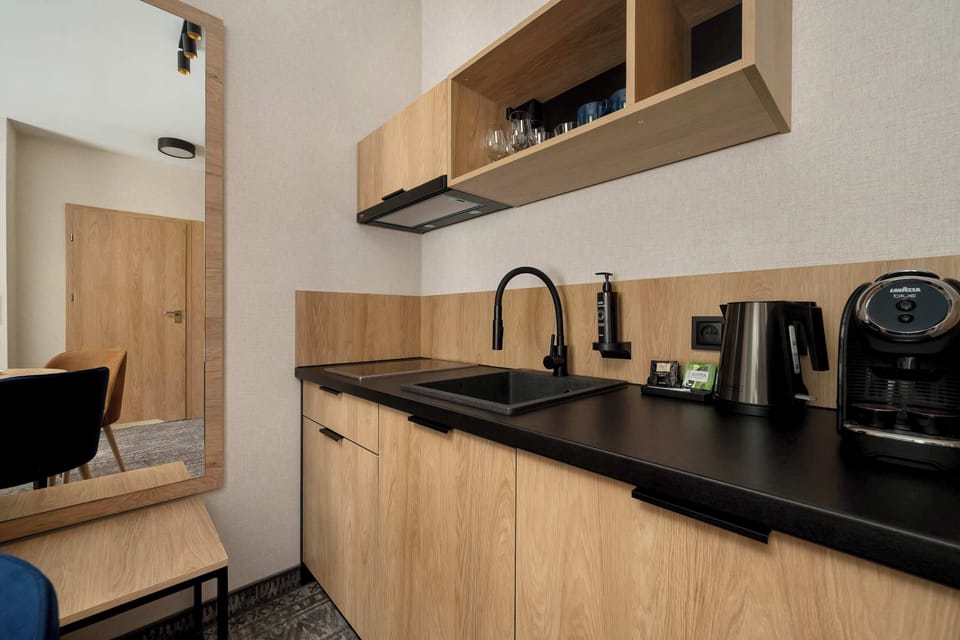A compact kitchen area with wooden cabinetry and a sleek countertop. The design is practical and modern.
