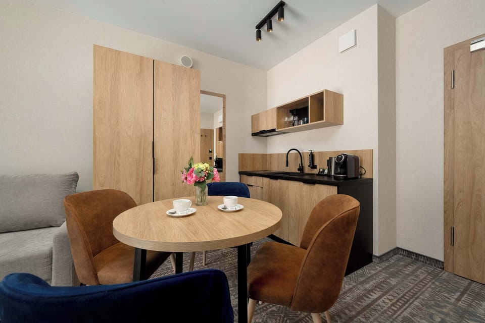 Another view of the dining space showing blue upholstered chairs around a round table. The design combines comfort with a modern aesthetic.