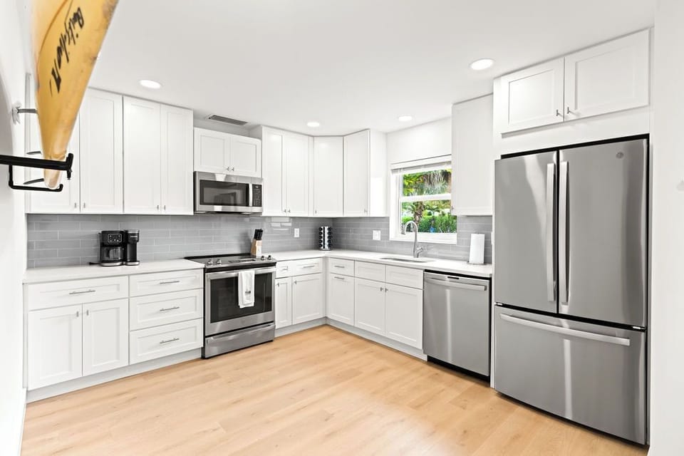 Chef’s kiss! 👨‍🍳 High-end stainless steel appliances and crisp white cabinetry make meal prep a breeze. Whether it's morning coffee or a full dinner, we’ve got you covered! ☕🍳✨