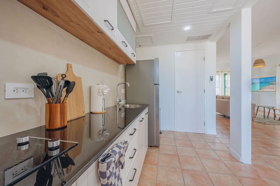 Modern kitchen with sleek appliances, wooden accents, and terracotta floors bright, functional, and perfect for easy meal prep.