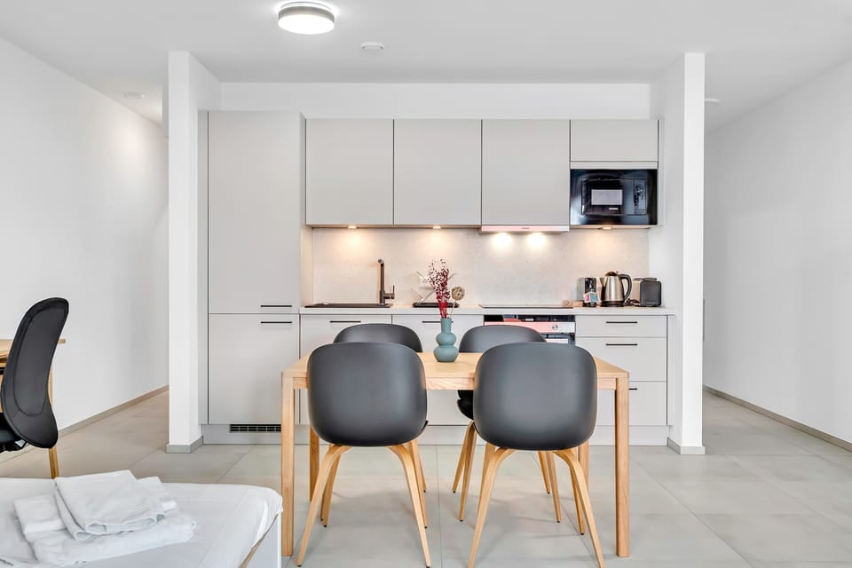 Modern kitchen and dining area fully equipped for cooking and enjoying meals at home.