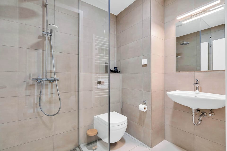 Modern bathroom with walk-in shower, clean finishes, and practical layout for a comfortable stay.